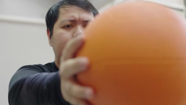 Азіатський жир людина намагається здійснювати з медициною м'яч у фітнес-зал, здоровий спосіб життя, втрата ваги бажання - Кадри, відео