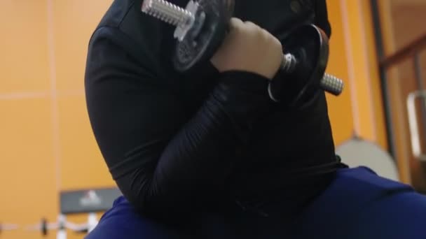 Азіатський товстий людина намагається здійснювати з гантелі в тренажерному залі, здоровий спосіб життя, втрата ваги бажання - Кадри, відео