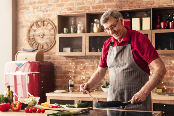 Caring senior man preparing breakfast at kitchen - Fotografie, Obrázek