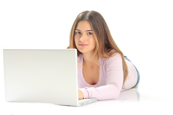 Hermosa joven sonríe mientras lee desde un ordenador portátil computar
 - Foto, Imagen