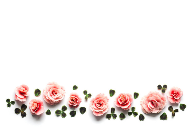 Lente achtergrond met roze Begonia bloemen en klaverblaadjes - Foto, afbeelding