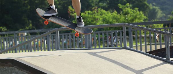 Skateboarder skateboarding in skate park in city - Фото, изображение