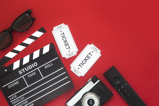 Concepto de fiesta de cine. entradas de cine, clapperboard, maíz pop y gafas 3d en un fondo rojo. Puesta plana
 - Foto, Imagen