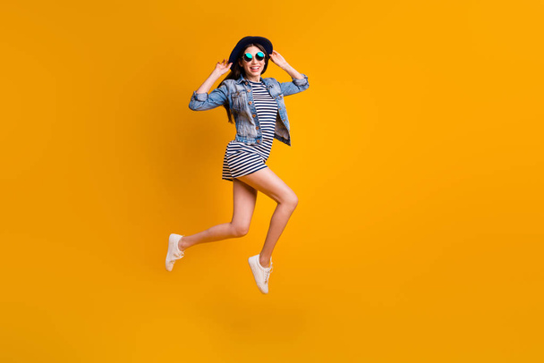 Full length body size view photo cute nice teen teenager summer free time holiday rejoice good-looking touch head specs eyewear eyeglasses striped jeans fashionable outfit isolated yellow background - 写真・画像