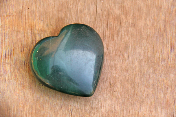 天然石の玉で作られた緑のハート。ハート型の石が嘘をつく - 写真・画像
