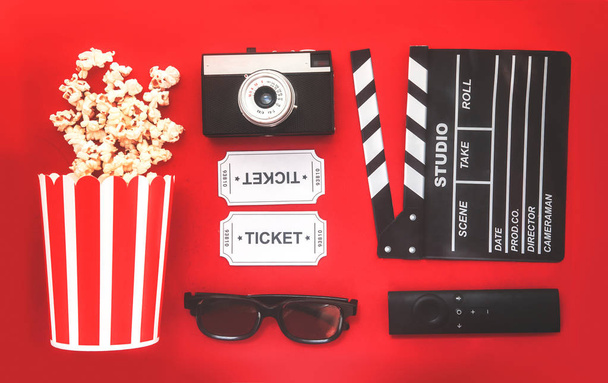 Koncepcja imprez kinowych. bilety filmowe, clapperboard, pop corn i okulary 3D w czerwonym tle. Płaski lay - Zdjęcie, obraz