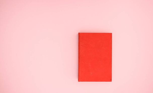 Red book on pink background  - Фото, изображение