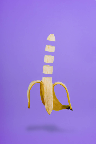 Banana Slice Isolated Flying on Purple Background - Zdjęcie, obraz