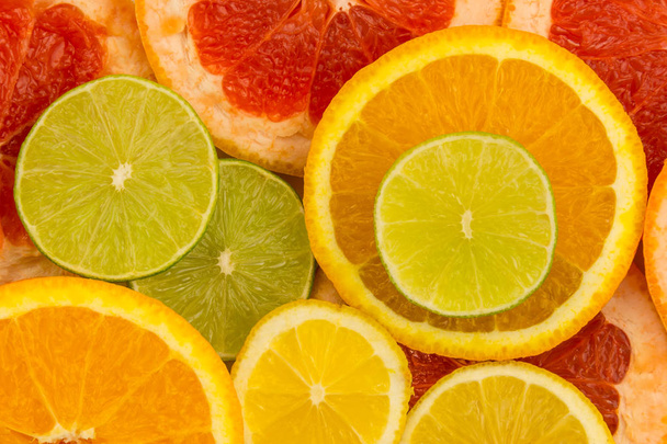 Four slices of citrus fruits, closeup background. - Photo, Image