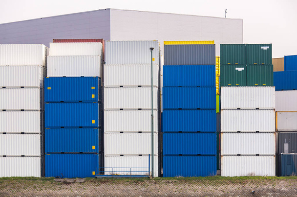 Στοίβα αγαθών εμπορευματοκιβωτίων φορτίου στο λιμάνι προβλήτα αποβάθρα περιμένει για διεθνείς θαλάσσιες μεταφορές εμπορευμάτων στο Ρότερνταμ λιμάνι των κάτω χωρών - Φωτογραφία, εικόνα