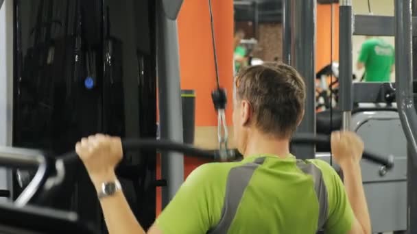 The overweight man shares the upper block in the gym. Fitness. Healthy lifestyle. - Video