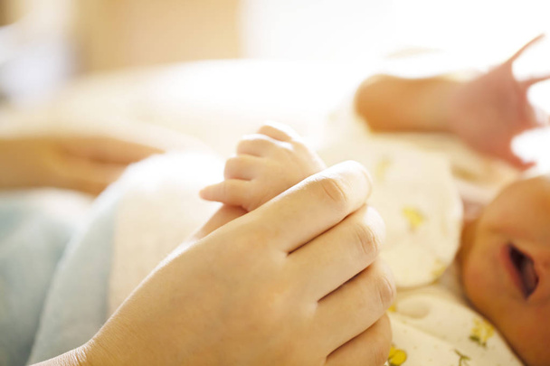 Holding Hands. hand the newborn baby in the hand of parent. - Foto, imagen