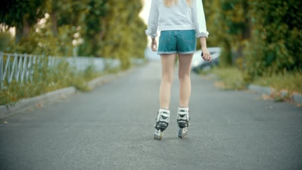 Nastoletni Dziewczyna w rolkach łyżwach na pustej drodze - Materiał filmowy, wideo