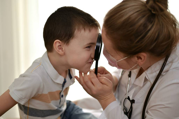 The child and the doctor look at each other. - Foto, imagen