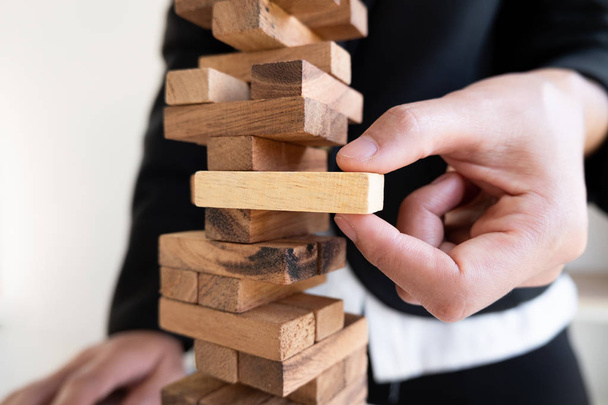 Afbeelding van hand holding blokken hout spel om te groeien van het bedrijfsleven, risico van management en strategieplan - Foto, afbeelding
