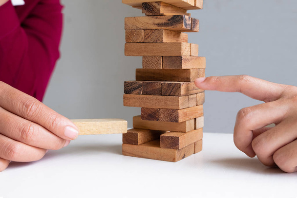 Image of hand holding blocks wood game to growing up of business, Risk of management and strategy plan - Photo, Image