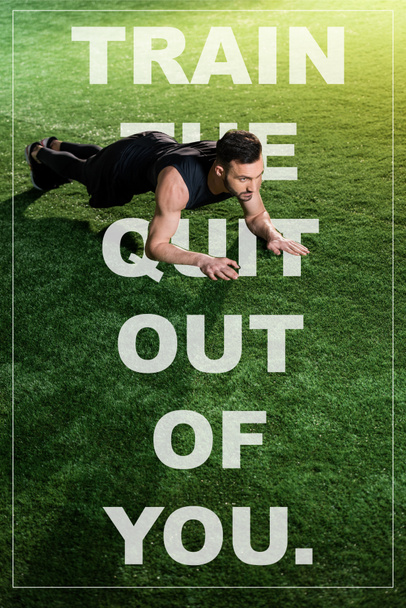 handsome athletic man doing plank exercise on green grass with train the quit out of you illustration - Valokuva, kuva
