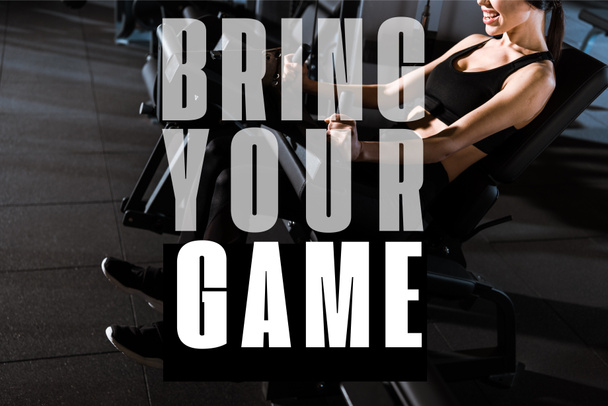 vista recortada de la mujer atlética haciendo ejercicio en el aparato de entrenamiento en el gimnasio con llevar su ilustración juego
 - Foto, imagen