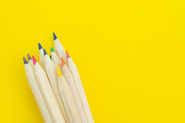 Vaious color pencils on solid yellow background, divesify or cre - Fotó, kép