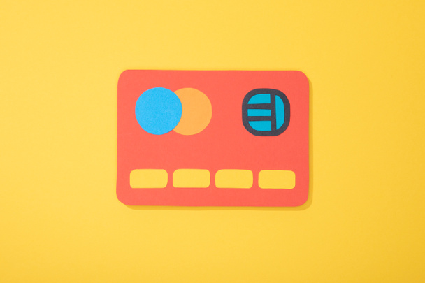 top view of red paper icon of credit card isolated on yellow  - Fotó, kép