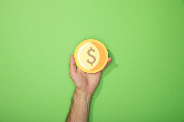 cropped view of man holding paper yellow coin on green - Fotoğraf, Görsel