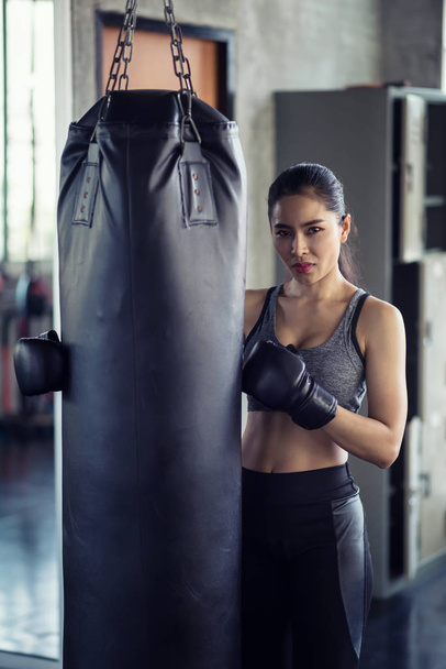 Athletic woman at punching bag in gym - Photo, Image