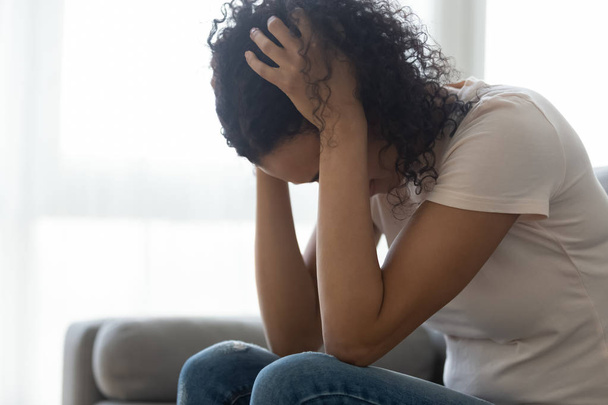 Sad hopeless black woman sit alone at home feeling depressed - Foto, Imagen