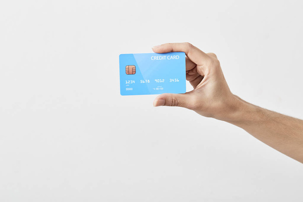 Credit card in hand on white - Foto, afbeelding