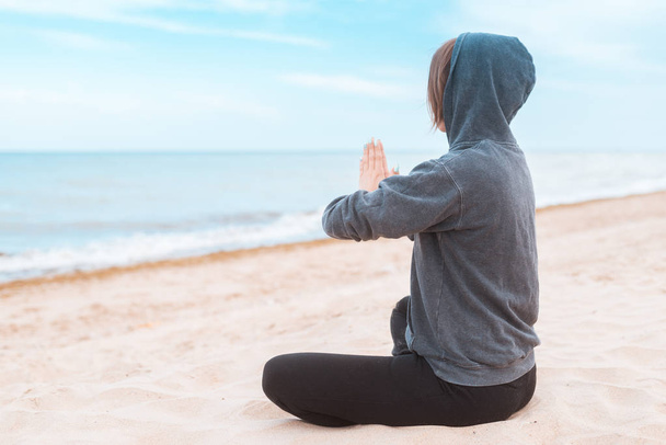 Woman practicing meditation on the seashore, ocean. Practice clearing thoughts, calming down. Yoga on the coast. - Foto, Imagem