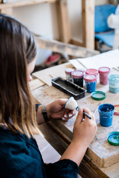 Lady artista de cerámica que trabaja en el interior de su estudio, mujeres manos pintando objetos
 - Foto, Imagen