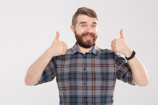 Success and good gesture concept - happy funny man showing thumbs up on white background - Foto, Imagen