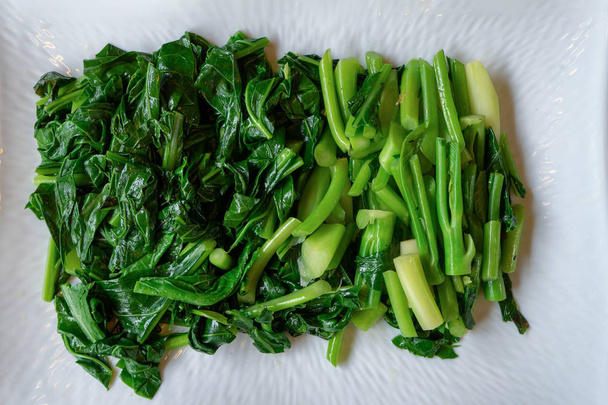Seperate slided and boiled Chinese (Thai) KALE vegetable lay on  - Foto, immagini
