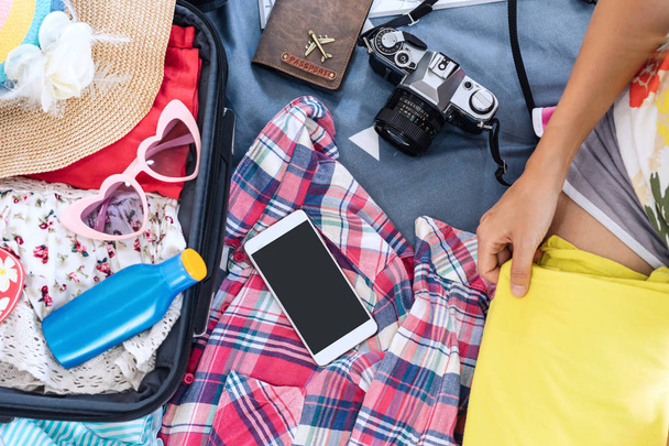 Young woman traveler packing her clothes and stuff in suitcase,  - Foto, Imagen