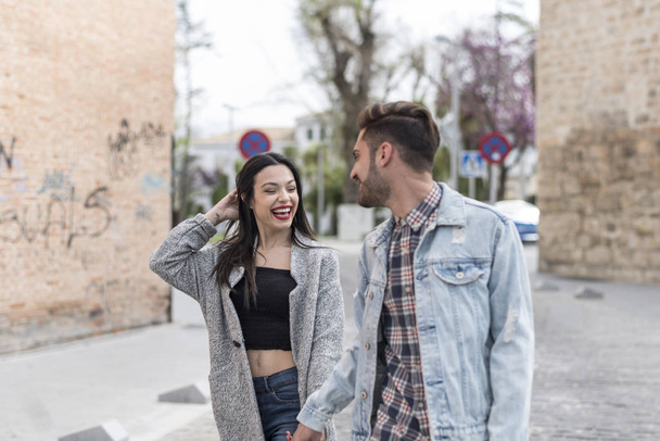 Young couple walking in the street smile and laughing - Foto, Bild