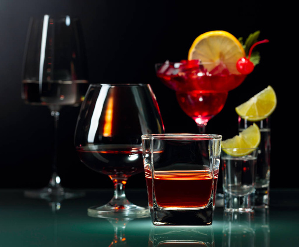 Διάφορα αλκοολούχα ποτά σε μαύρο φόντο. - Φωτογραφία, εικόνα
