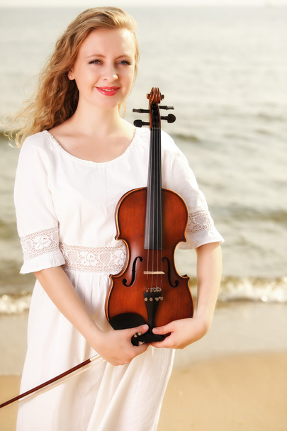 The blonde girl with a violin outdoor - Foto, Imagen