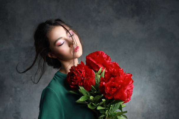 beautiful girl with red peony flowers - 写真・画像