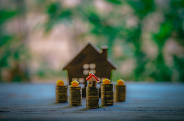 ein kleines Haus auf einem Haufen von Münzen wird als Vermögenswert verwendet, finanzielle  - Foto, Bild