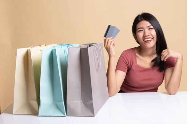 Young Asian woman with shopping bag and blank card. - Valokuva, kuva