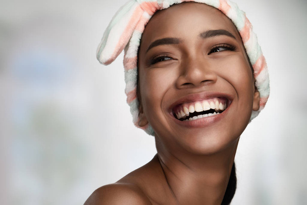 Közeli portréja egy gyönyörű mosolygó boldog nő, tiszta bőr izolált világos háttérrel. Kozmetikai kezelések és kozmetikai Spa terápia - Fotó, kép