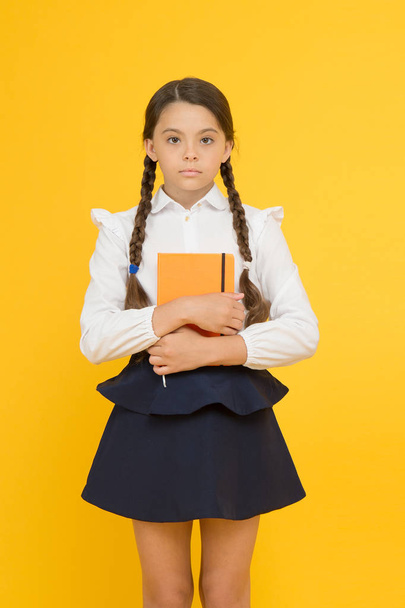 Study foreign language. Essay for homework. KId girl student likes to study. Study literature. Private lesson. Adorable child schoolgirl hold copybook. Formal education. School club after classes - Photo, image