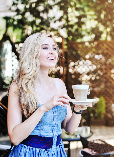 Gyönyörű fiatal nőt pózol a koffein csésze latte. - Fotó, kép