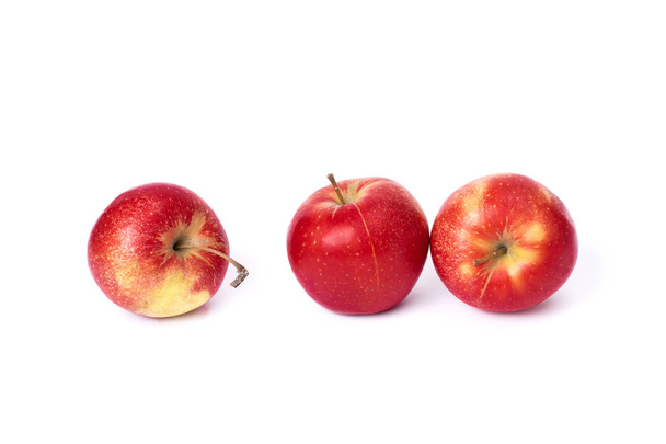 Three red apples on a white background. Juicy apples of red color with yellow specks on a white background. A group of ripe apples on an isolated background. - Valokuva, kuva