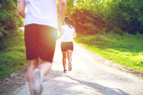 Młodzi ludzie jogging i ćwiczenia w przyrodzie, widok z tyłu - Zdjęcie, obraz