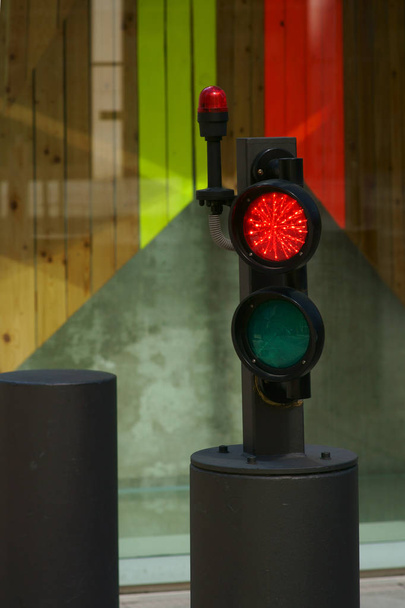 Bollard with traffic light / A bollard with a light barrier and traffic light on the driveway to a skyscraper. - 写真・画像