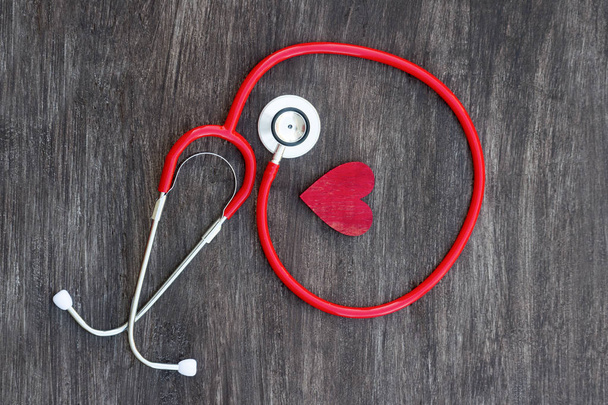 Stetoskooppi ja punainen sydän puupohjalla. Terveydenhuoltopalvelut
 - Valokuva, kuva