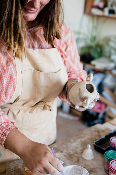 Keramikkünstlerin arbeitet in ihrem Atelier, Frauenhände malen Objekte - Foto, Bild