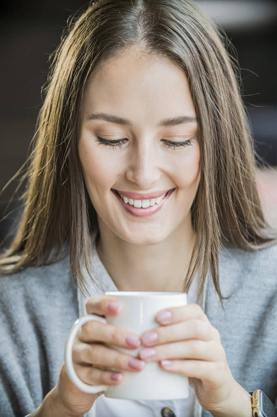 ritratto di una bella ragazza con una tazza di caffè in un caffè
 - Foto, immagini