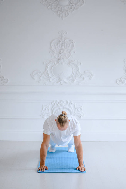 Man practicing advanced yoga against a white background - Foto, Bild