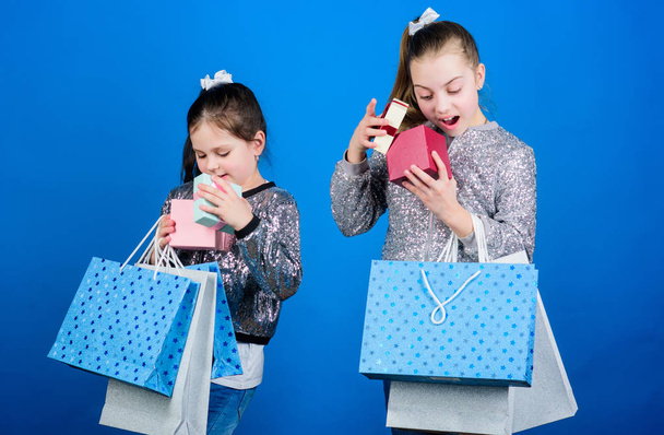 Shopping day. Kids fashion. Girls sisters friends with shopping bags blue background. Every product delivered to you. Shopping and purchase. Black friday. Sale and discount. Children bunch packages - Foto, Imagem